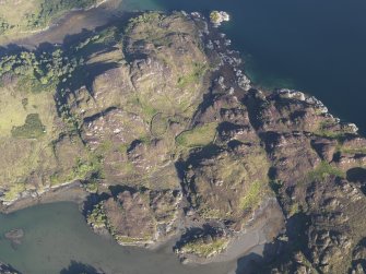 Oblique aerial view of the enclosures, buildings and fish trap, looking ESE.