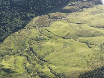 Oblique aerial view of the field boundaries, rig and shieling huts, looking SSW.