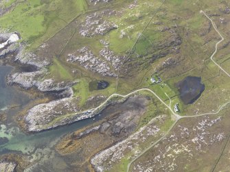 Oblique aerial view of the bay with the pier and Dun Mor a' Chaolais broch adjacent, looking to the WNW.