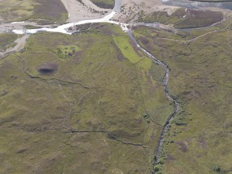 Oblique aerial view of the farmsteads and field boundaries, looking SE.