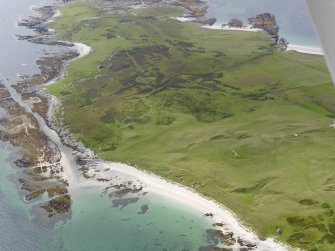 Oblique aerial view of shell middens lying in the dunes above Traigh Uamha Seilbhe, looking towards the field system on Druim Mor, taken from the NE.