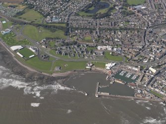 General oblique aerial view of the harbour area, centred on the lighthouse, taken from the E.