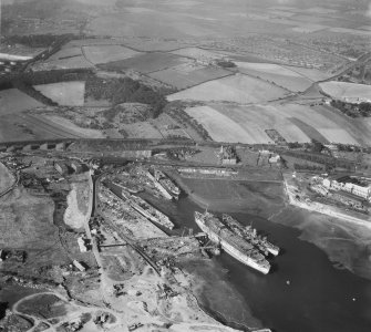 Thomas Ward and Sons Shipbreaking Yard, Inverkeithing.  Oblique aerial photograph taken facing north-west.  The vessels include a mine damaged large bulk carrier, a small bulk carrier, two large passenger liners and a general cargo ship.