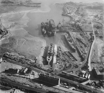 Thomas Ward and Sons Shipbreaking Yard, Inverkeithing.  Oblique aerial photograph taken facing east.  The vessels include a mine damaged large bulk carrier, a small bulk carrier, two large passenger liners and a general cargo ship.