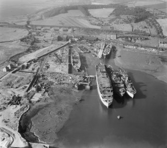 Thomas Ward and Sons Shipbreaking Yard, Inverkeithing.  Oblique aerial photograph taken facing west.  The vessels include a mine damaged large bulk carrier, a small bulk carrier, two large passenger liners and a general cargo ship.