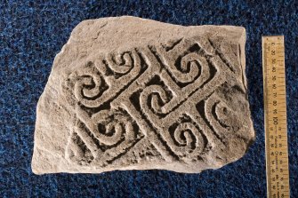 View of fragment of cross slab, Drainie no 2, with spiral decoration (with scale)