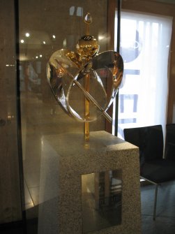 View of sculpture 'The Three Honours', in glass case beside the waiting room in main hall area of the Scottish Parliament building.