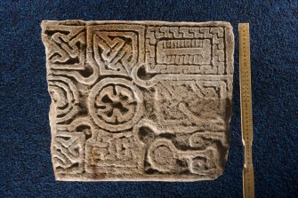 View of fragment of cross slab, Drainie no 32, displaying mirror, comb and torc Pictish symbols (including scale)