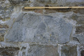 View of stone set into rear wall of church (daylight with scale)