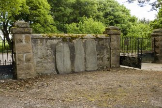 View of Knockando Pictish symbol stones nos 1 and 2 and sculptured stone no 3 set into wall of churchyard