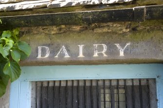 Courtyard, N range, detail of 'dairy' sign on lintel above door