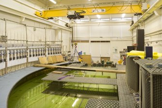 Interior. Curved wave tank building. View of modular work platforms, signal processing receivers (left) and the 'beaches' on the right