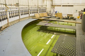 Interior. Curved wave tank building. View of tank with its modular work platforms, signal processing receivers (left) and 'beaches' on the right