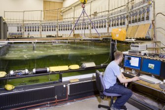 Interior. Curved wave tank building. Curved Wave Tank and Control desk showing the array of 'ducks' or wave energy devices. The two 'ducks' on the left are spine models, followed by a 'sucked toffee' type duck made from an extruded foam material. On the extreme right is an example of the original  1970's 'duck' design constructed in the workshops in the Fleeming Jenkin Building, University of Edinburgh (NT27SE 526.22)