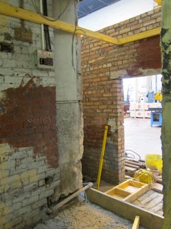 Interior. View of Building 1A1, south west end looking towards the west end of the south wall of Building 2. The original masonry stairwell wall is out of shot on the right. Note the original masonry south wall of 1A1 and the blocked access to the left (in brick) to the west end of 1A1.