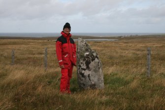 View of the only upright stone of the circle, with Mr Ian Parker, RCAHMS.
