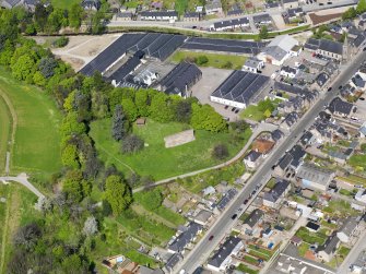 Oblique aerial view of Rothes Castle and Glen Spey Distillery, taken from the SE.