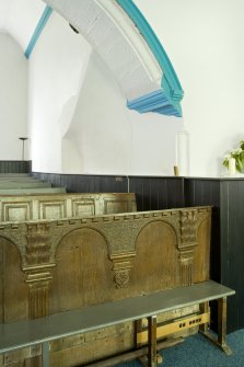 Interior. N range and carved pew fronts. Detail