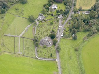 Oblique aerial view of Kirkland, centred on Glencairn Parish Church, taken from the WNW.