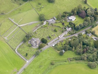 Oblique aerial view of Kirkland, centred on Glencairn Parish Church, taken from the SW.