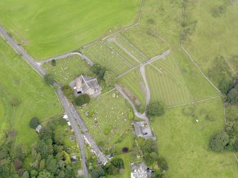 Oblique aerial view of Kirkland, centred on Glencairn Parish Church, taken from the SE.