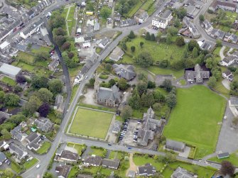 Oblique aerial view of Newton Stewart, centred on Penninghame Parish Church, taken from the NW.