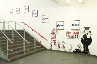 Interior. View of main supporters' staircase at ground floor level within Richard Donald stand, showing the graffiti by a local cartoonist.