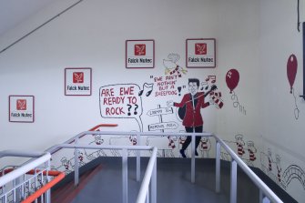 Interior. View of landing on main supporters' staircase within Richard Donald stand, showing graffiti by local cartoonist.