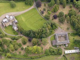Oblique aerial view of Caprington Castle and stables, taken from the NW.