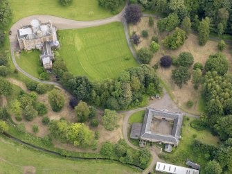 Oblique aerial view of Caprington Castle and stables, taken from the WNW.