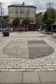 General view of town crest inlaid in paving on Guildford Square, Rothesay, Bute, from W