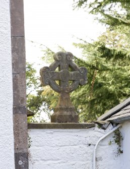 Detail of carved stone cross on wall head in north west corner of courtyard.