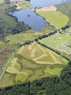 General oblique aerial view of the crannog in Loch Heron with the camp site in the foreground, taken from the NE.