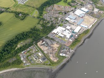 Oblique aerial view of Carriden Parish Church with warehouses and sewage works adjacent, taken from the ENE.