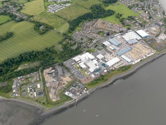 Oblique aerial view of Carriden Parish Church with warehouses and sewage works adjacent, taken from the NE.