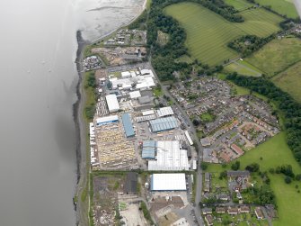 Oblique aerial view of Carriden Parish Church with warehouses and sewage works adjacent, taken from the WNW.