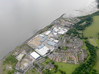 Oblique aerial view of Carriden Parish Church with warehouses and sewage works adjacent, taken from the WSW.