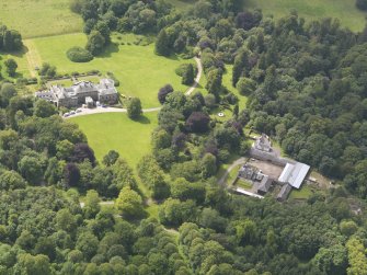 Oblique aerial view of Springkell House and stables, taken from the NE.