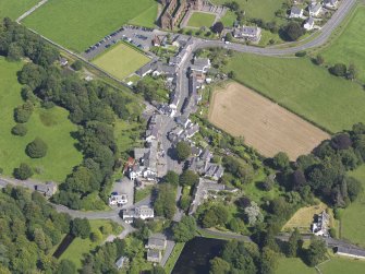 Oblique aerial view of New Abbey, centred on Main Street, taken from the WSW.