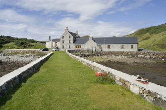 View of Rodel Hotel, Harris, looking along south wall of harbour, from south-east.