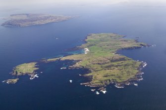 General oblique aerial view of the Island of Muck and Eilean nan Each with Eigg in the background, taken from the SW.