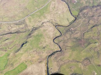 Oblique aerial view of the remains of a dun, township, field system and lazy beds at Peinduin, Skye, taken from the W.