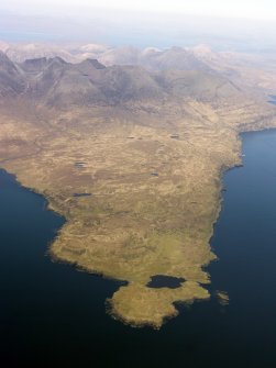 General oblique aerial view of the remains of the harbour at Rubh' an Dunain, looking towards the Cuillins, Isle of Skye, taken from the W.