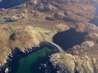 Oblique aerial view centred on Loch Sandig and the remains of the buildings, enclosures, field boundaries and lazy beds, taken from the NNW.