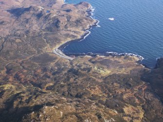 General oblique aerial view of the remains of the township at Usinish Bay, associated field boundaries and lazy beds, and the remains of hut circles, souterrains and an aisled roundhouse at Uamh Iosal and Uamh Ghrantraich, S Uist, taken from the W.