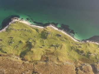 Oblique aerial view of the remains of the township buildings, field boundaries and lazy beds on Scarp, off the Isle of Harris, taken from the W.