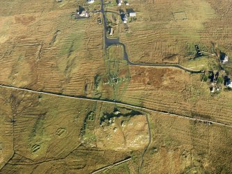 Oblique aerial view centred on the stone circle and stone row, the remains of the buildings and lazy beds at Calanais, taken from the SSW.