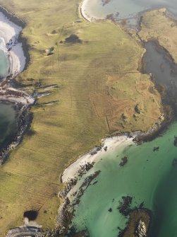 General oblique aerial view of the remains of an enclosure and lazybeds at Gearraid Mhartain and the remains of fish traps at Moronish, Vallay, North Uist, taken from the NW.