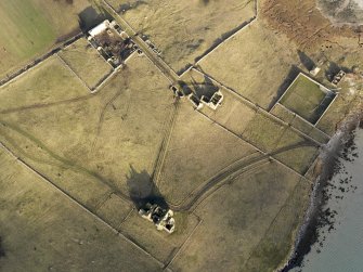 Oblique aerial view of the remains of Vallay House and Old Vallay House, Vallay, North Uist, taken from the SSW.