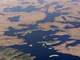 General oblique aerial view of Loch an Duin and the location of the remains of two duns and a broch, North Uist, taken from the SSW.